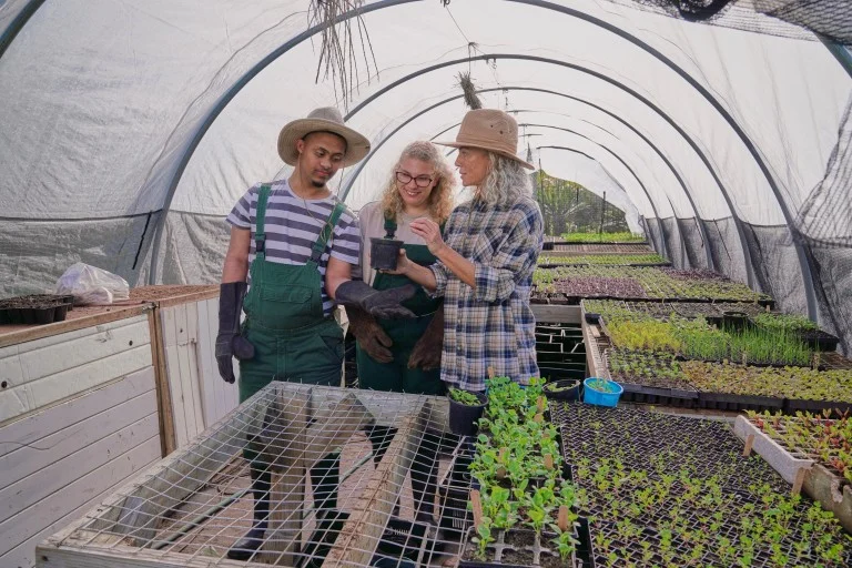 Two disabled friends gardening with support worker